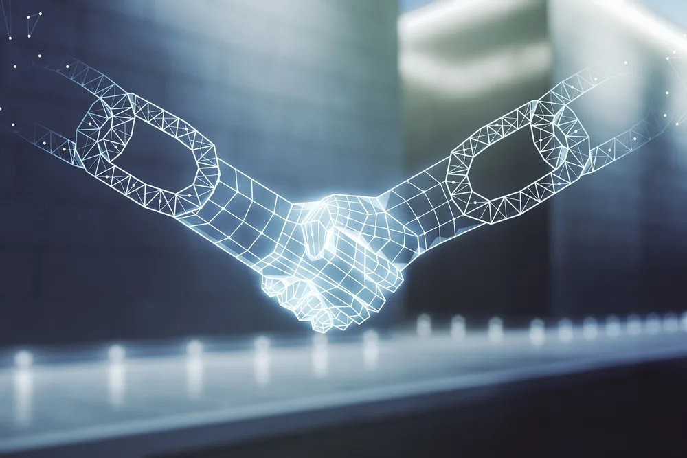 Digital picture of two robotic-looking hands shaking to illustrate an article about the consensus mechanism in blockchain.