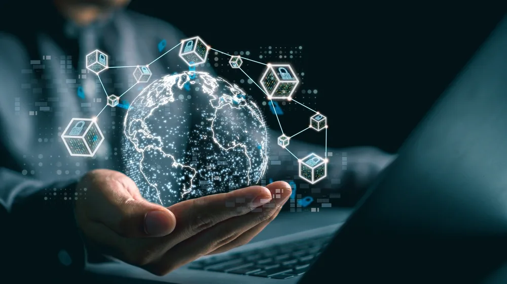 Picture of a hand with techie images floating around it to accompany an article about decentralisation.